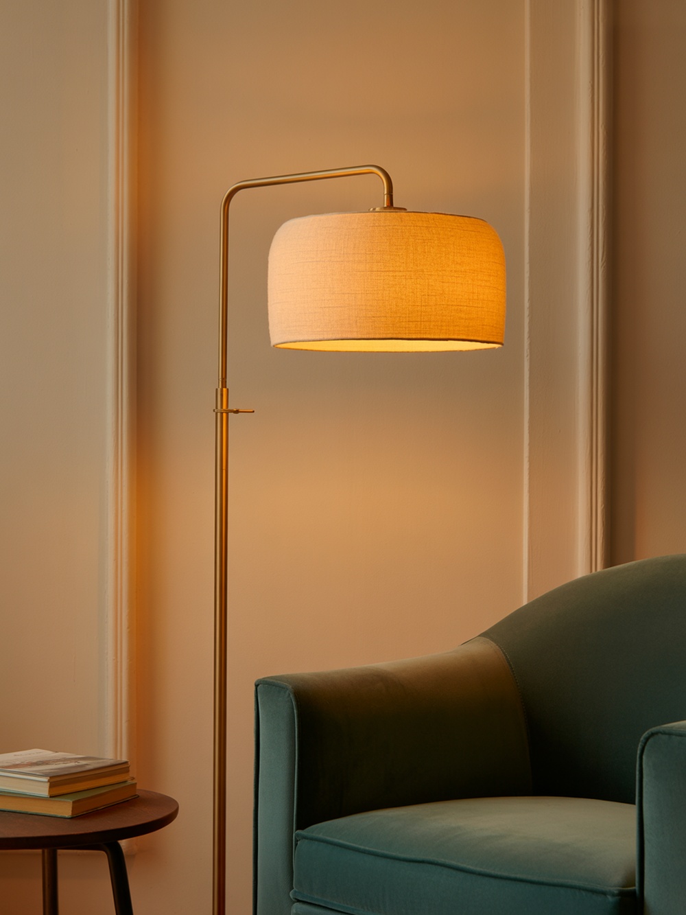 A stylish floor lamp illuminating a cozy reading nook with an open book on a small table.